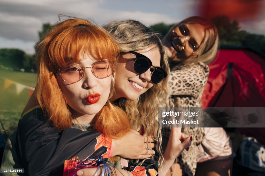 Smiling friends gesturing while enjoying in party at music festival