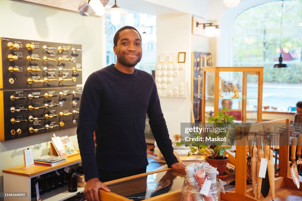 Portrait of smiling young owner standing at furniture store