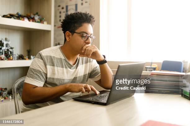 teenage boy studying with laptop at home - boys stock pictures, royalty-free photos & images
