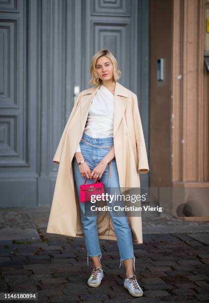 Mandy Bork is seen wearing white blouse Zara, cropped denim jeans Zara, red Hermes mini bag, beige &other stories trench coat, shoes Golden Goose,...