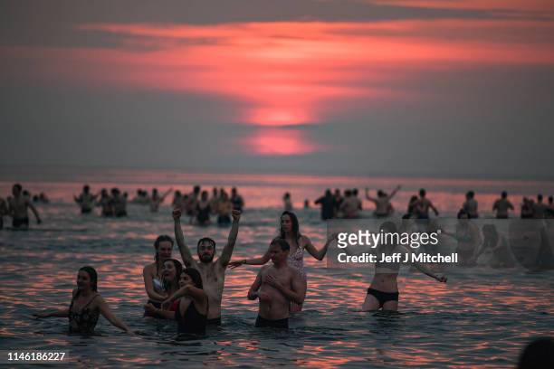Students from St Andrews University take part in the traditional May Day dip into the North Sea at East Sands beach on May 1, 2019 in St Andrews,...
