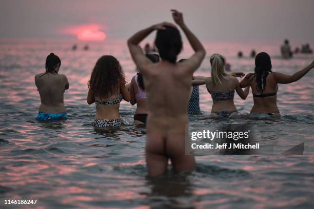 Students from St Andrews University take part in the traditional May Day dip into the North Sea at East Sands beach on May 1, 2019 in St Andrews,...