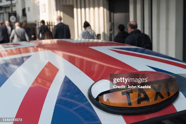 General view of a London black taxi roof light sign with the roof decorated with a Union Jack flag on April 30, 2019 in London, England.