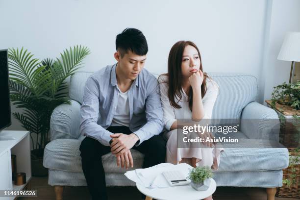 worried couple looking anxious as they going through financial difficulties - law problems stock pictures, royalty-free photos & images