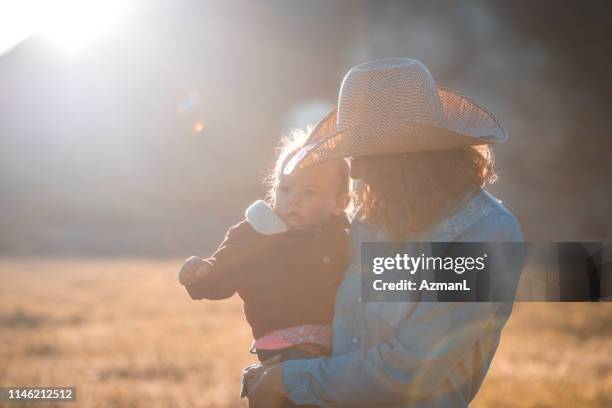 jonge cowgirl en baby in utah grasland - western shirt stockfoto's en -beelden