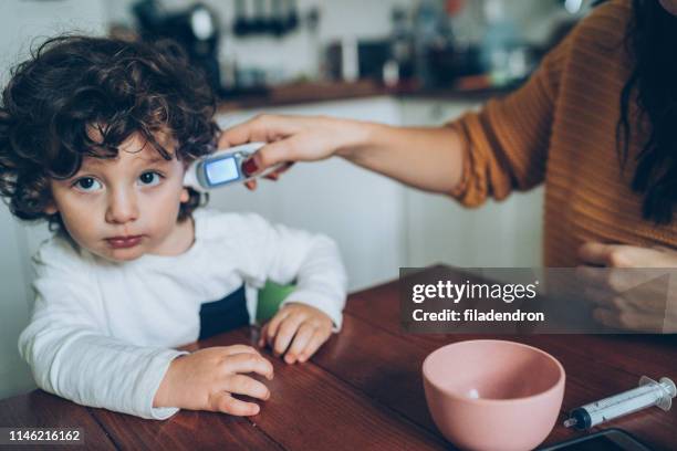 measuring little boy's temperature - baby ear infection stock pictures, royalty-free photos & images