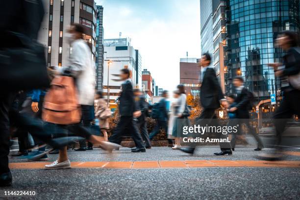 verschwommene geschäftsleute auf dem weg von der arbeit - tokyo japan stock-fotos und bilder