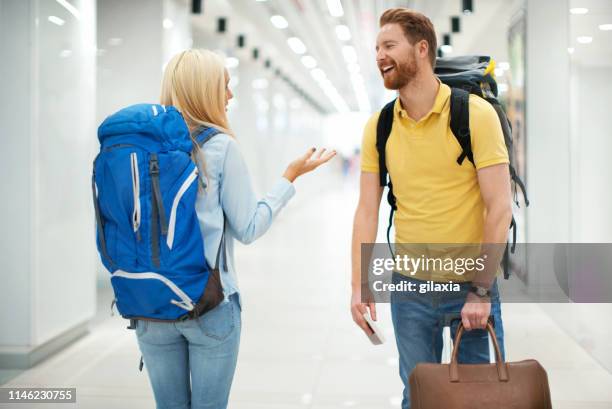 young couple at an airport. - yellow suitcase stock pictures, royalty-free photos & images