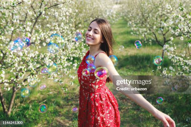 young woman among blooming trees - multi coloured dress stock pictures, royalty-free photos & images