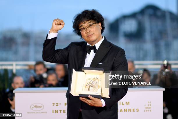 South Korean director Bong Joon-Ho poses during a photocall with his trophy after he won the Palme d'Or for the film "Parasite " on May 25, 2019...