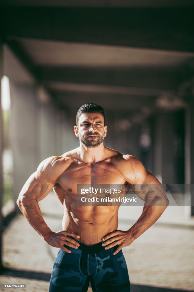 Handsome muscular man. Bodybuilder. Fashion model. Handsome sportsman posing after workout.
