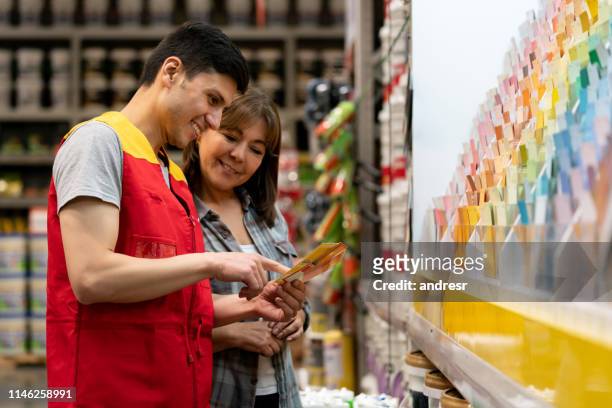 mujer en la tienda de mejoras de casa comprando pintura y hablando con un vendedor - hardware store fotografías e imágenes de stock