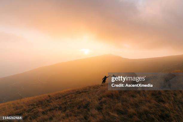 mountain bikers geven high-five bij zonsondergang - middlebare afstand stockfoto's en -beelden