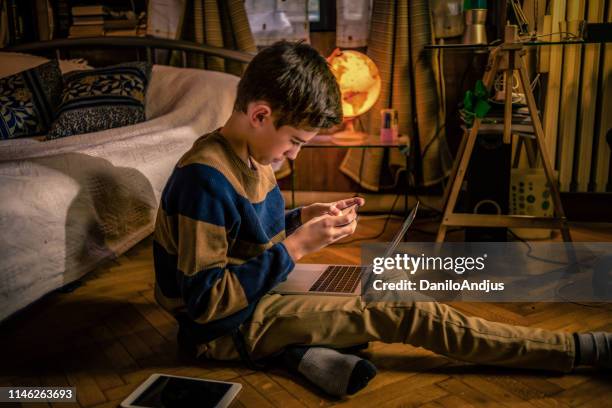 young teenager using his smartphone in his bedroom at home - world literature stock pictures, royalty-free photos & images