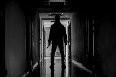 murder, kill and people concept - Criminal or murderer wearing a mask in silhouette holding knife inside a condo at crime scene