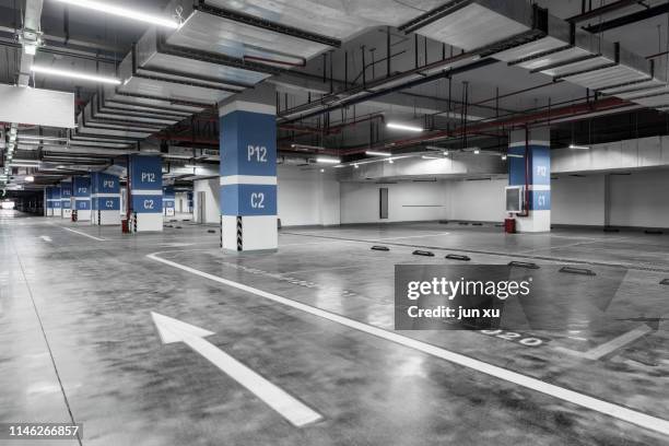 empty and bright underground parking lot - parking garage stock-fotos und bilder