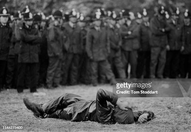 View of a striking miner as he lays on the ground in front of a line of police officers near the Orgreave coking plant, Orgreave , Yorkshire,...