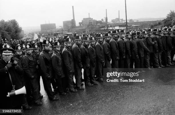 View of lines of police officers as they block the road to near the Orgreave coking plant, Orgreave , Yorkshire, England, May 1984. Though the mine's...