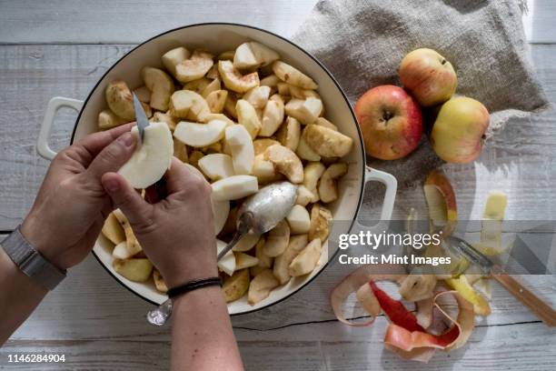 high angle close up of person placing apples in a round baking tin. - apple pie stock pictures, royalty-free photos & images