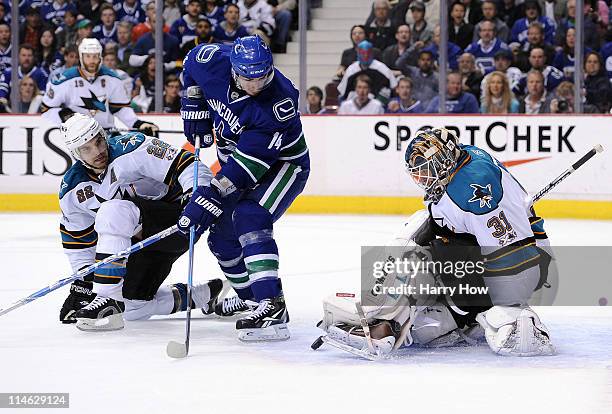 Goaltender Antti Niemi of the San Jose Sharks makes a save as Dan Boyle of the San Jose Sharks defends Alex Burrows of the Vancouver Canucks in the...