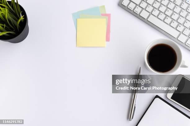 computer keyboard with coffee, smart phone, pot of plant and office supply on white background - desk from above fotografías e imágenes de stock