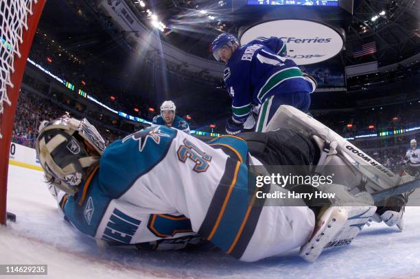 Alex Burrows of the Vancouver Canucks puts the puck on net as goaltender Antti Niemi of the San Jose Sharks makes a save and the puck goes just wide...