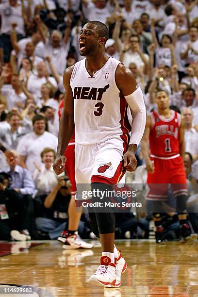Dwyane Wade of the Miami Heat celebrates as Derrick Rose of the Chicago Bulls looks on dejected in Game Four of the Eastern Conference Finals during...