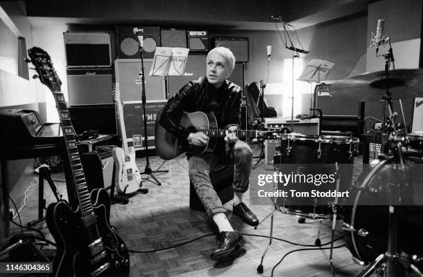 British musician Mr Hudson plays an acoustic guitar in a recording studio, London, England, December 2010.