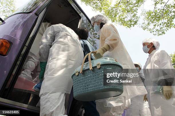 Minamisoma City residents, wearing radiation protective clothing, prepare for temporary return within the exclusion zone, 20km radius from the...