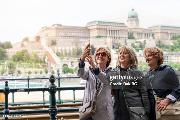 female senior friends exploring the city on vacation - hungary stock pictures, royalty-free photos & images