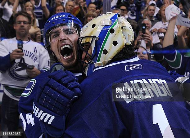 Alex Burrows and goaltender Roberto Luongo of the Vancouver Canucks celebrate after defeating the San Jose Sharks 3-2 in double-overtime in Game Five...