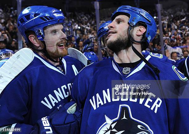 Daniel Sedin and Kevin Bieksa of the Vancouver Canucks celebrate after defeating the San Jose Sharks 3-2 in double-overtime in Game Five to win the...
