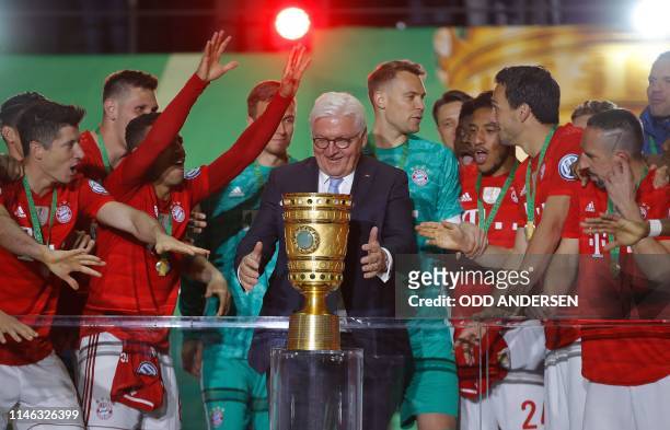 Germany's President Frank-Walter Steinmeier hands over the trophy to Bayern Munich's German goalkeeper Manuel Neuer after the German Cup Final...