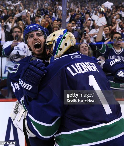 Alex Burrows and goaltender Roberto Luongo of the Vancouver Canucks celebrate after defeating the San Jose Sharks 3-2 in double-overtime in Game Five...