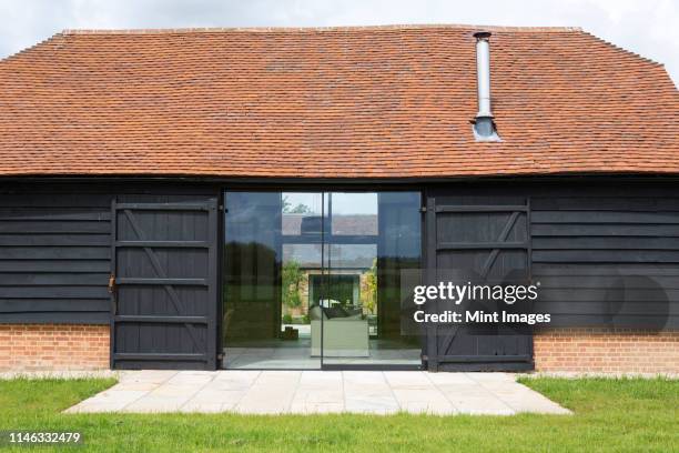 glass sliding doors of converted barn home - barn stock pictures, royalty-free photos & images