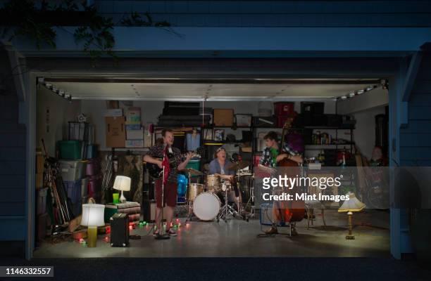 caucasian band playing in garage - singing inside stock-fotos und bilder
