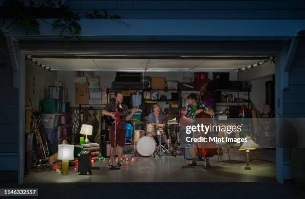 caucasian band playing in garage - man playing guitar photos et images de collection