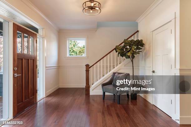 armchair and tree in house entryway - entrance stockfoto's en -beelden