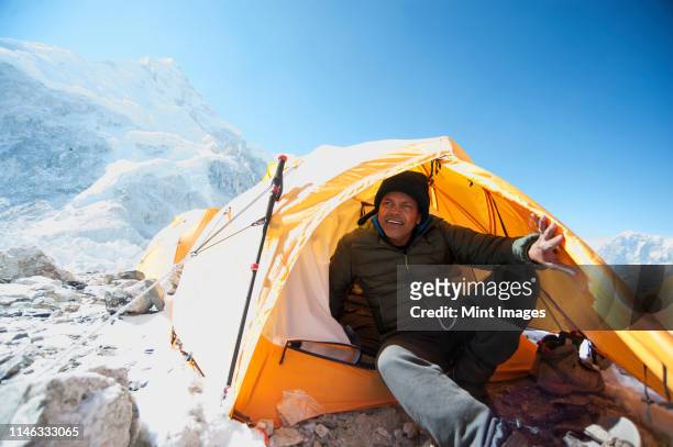 man sitting in base camp tent, everest, khumbu glacier, nepal - mt everest base camp stock pictures, royalty-free photos & images