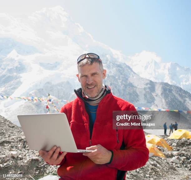 man using laptop on snowy mountain - geologist stock pictures, royalty-free photos & images