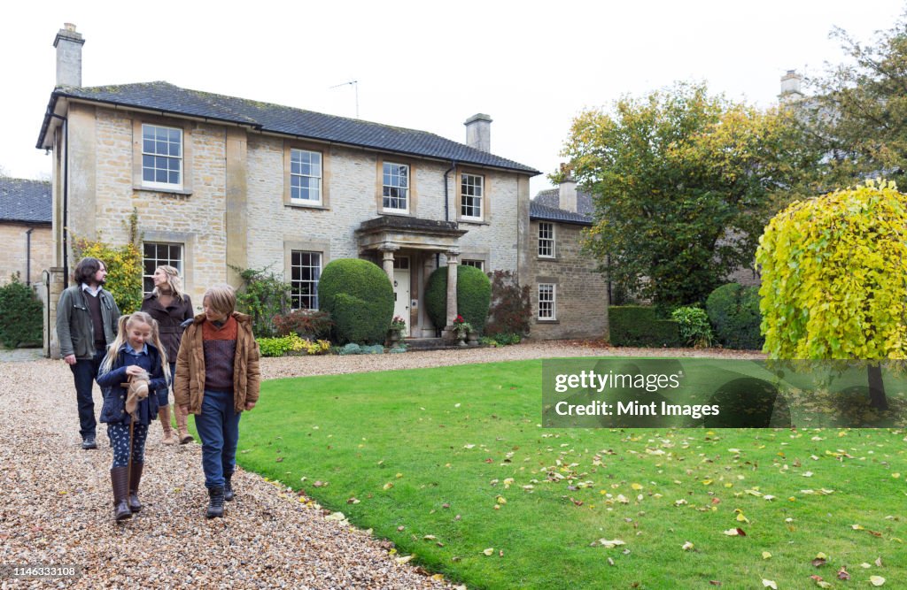 Caucasian family walking on driveway