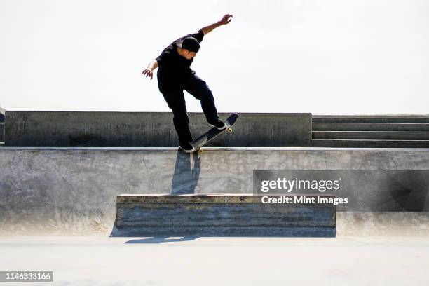 caucasian man riding skateboard in skate park - skateboard fall stock-fotos und bilder