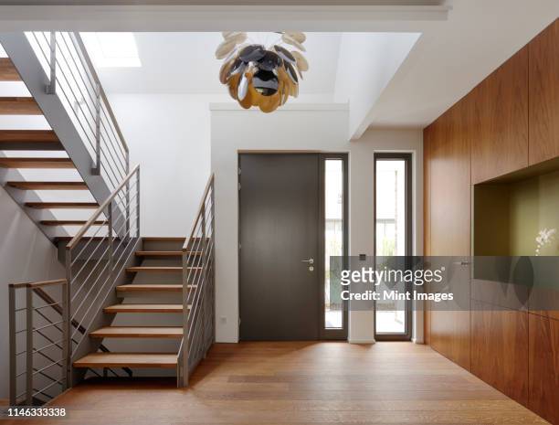 plank floor and walnut wall covering in home near staircase - indoors stock-fotos und bilder