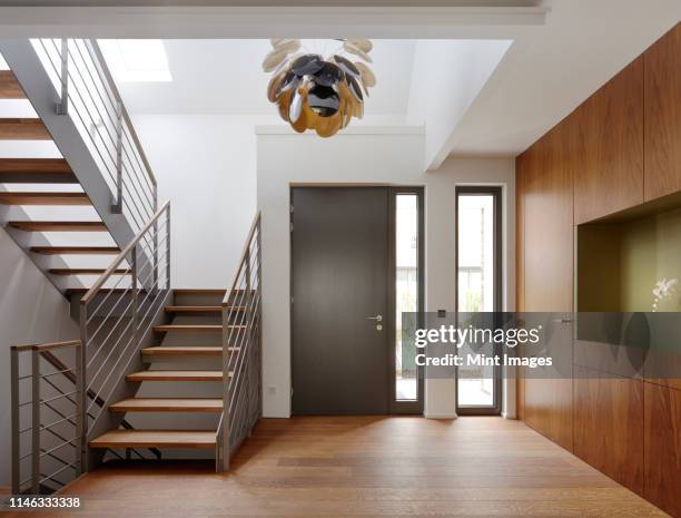 plank floor and walnut wall covering in home near staircase - modern front door step stock pictures, royalty-free photos & images