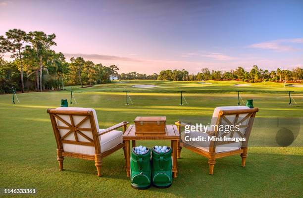 chairs and golf balls on driving range - drivingrange stockfoto's en -beelden