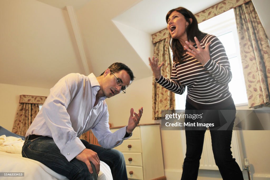 Caucasian couple arguing in bedroom