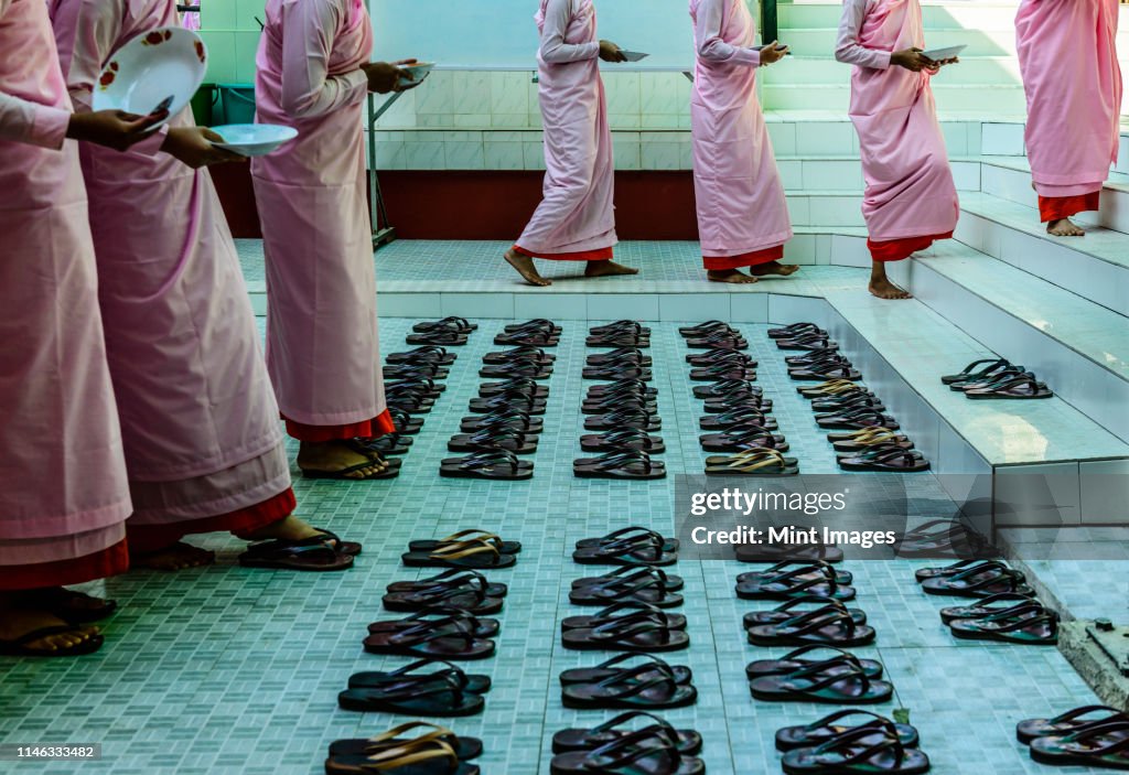 Monks leaving sandals near staircase