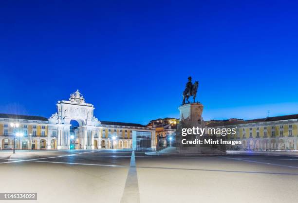 illuminated fountain and ornate buildings in commerce square, lisbon, portugal - comercio stock-fotos und bilder