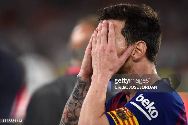Barcelona's Argentinian forward Lionel Messi covers his face at the end of the 2019 Spanish Copa del Rey final football match between Barcelona and...