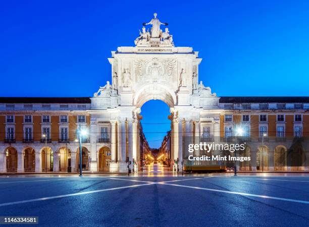 illuminated ornate archway in commerce square, lisbon, portugal - comercio stock-fotos und bilder